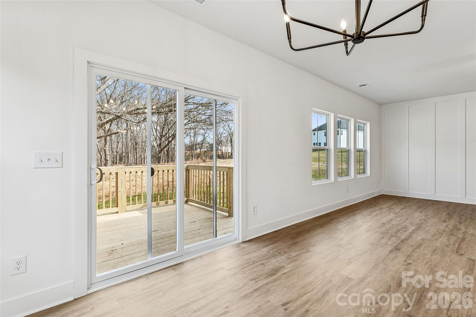 Dining area with sliding glass doors opening onto the back deck, surrounded by natural light from multiple windows