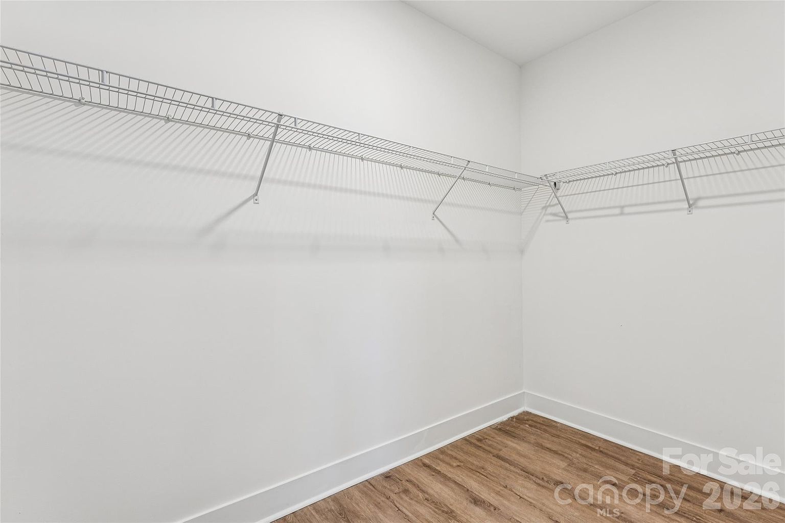 Walk-in closet with wire shelving and hanging rod providing generous storage space