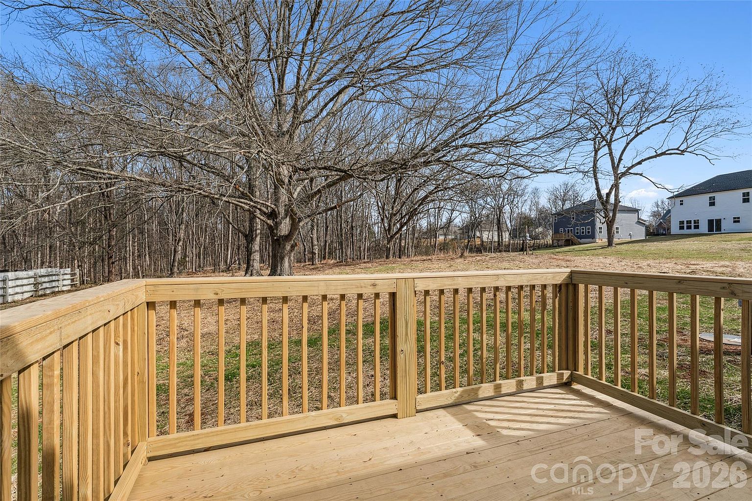 View from the wooden back deck looking out at the spacious yard and mature trees