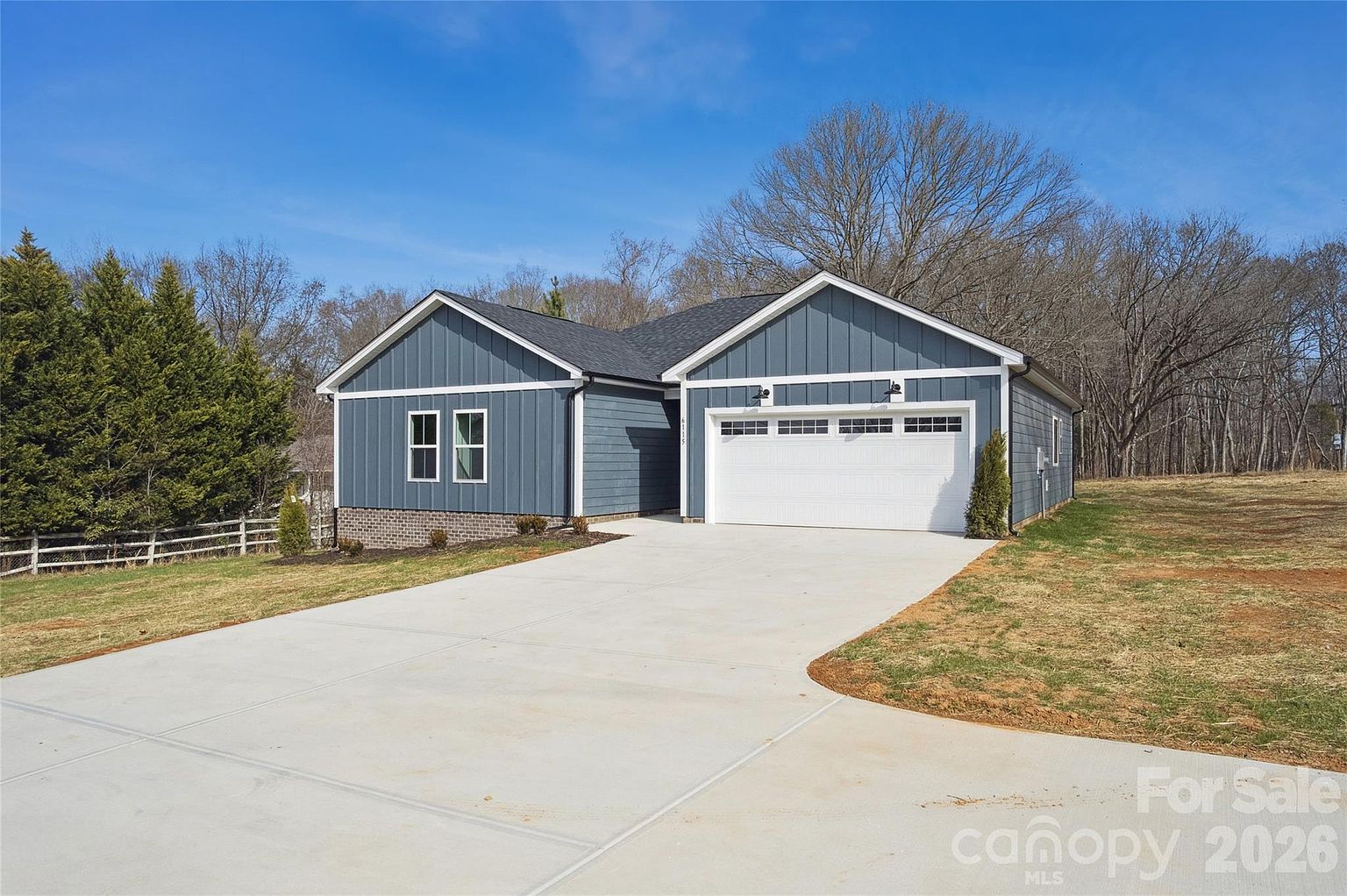 Front exterior showing the full width of the single-story home with attached garage and wide concrete driveway